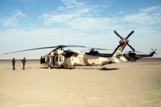 An image of a helicoptor with soldiers nearby